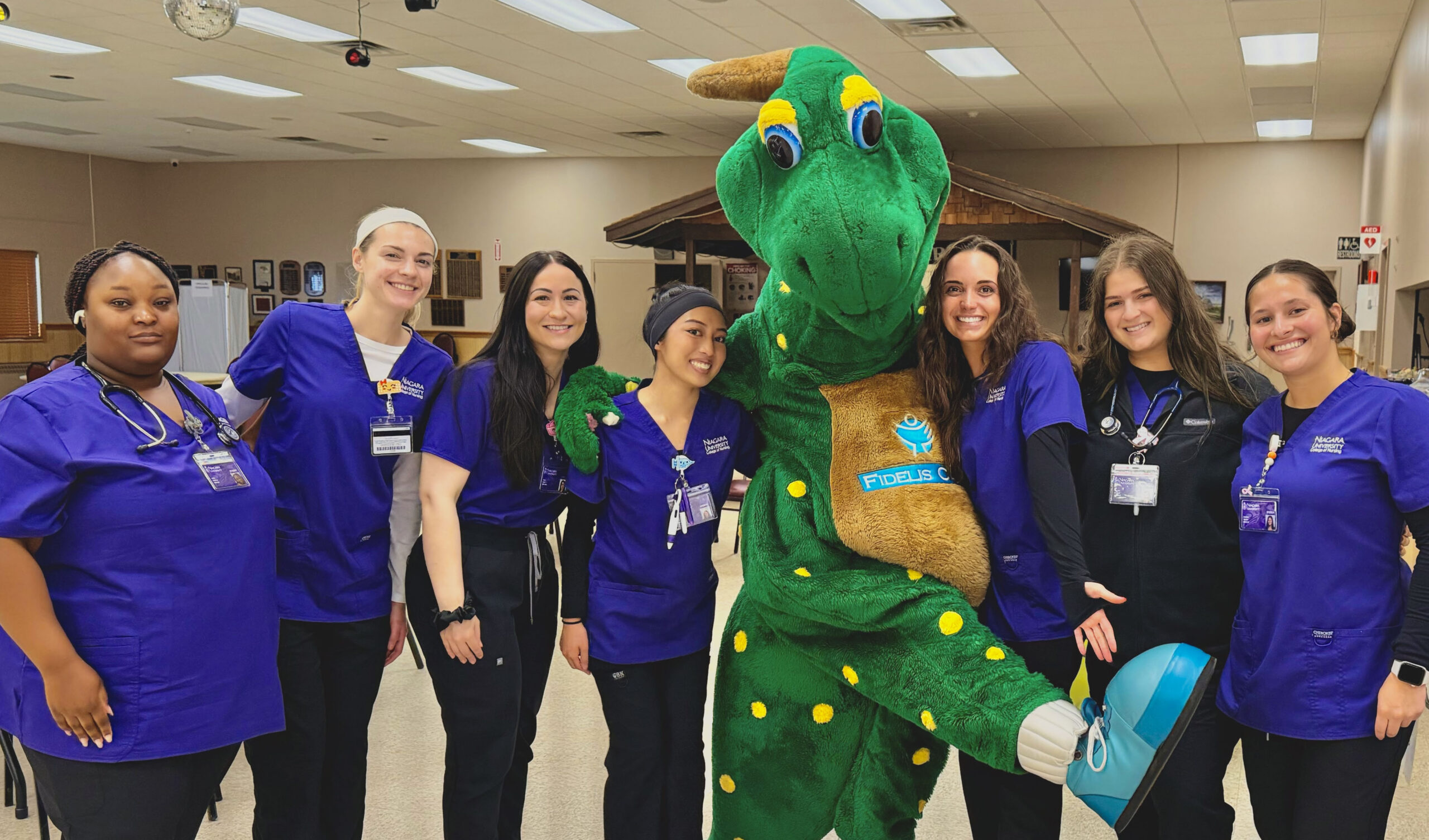 NU Nursing Students at a hospital with the Fidelis Care Green Dinosaur
